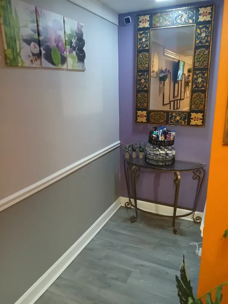 Massage Unique studio hallway with purple accent wall and decorative mirror