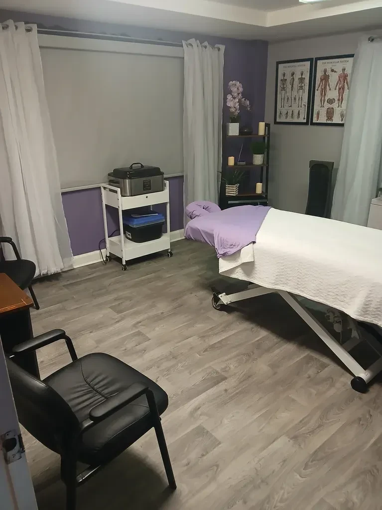 Massage Unique treatment room with massage table and purple accents